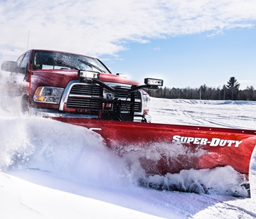 Red Ford Super Duty with Meyer Super-Duty snow plow clearing a winter road