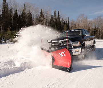 Blue pickup truck with Meyer XT snow plow pushing snow off a road