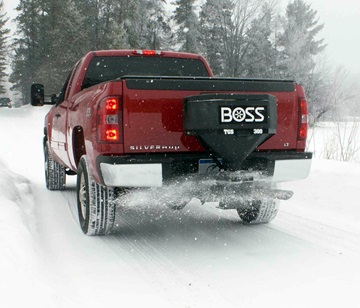Red Silverado with BOSS TGS spreader spreading salt on a winter road